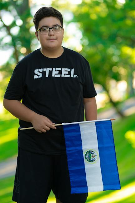 A Man in Black Crew Neck T-shirt Holding Blue and White Flag