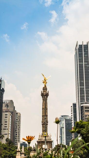 Gold Statue in the Middle of City Buildings